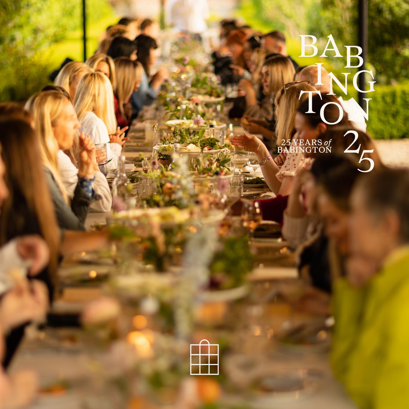 Guests seated at a long, outdoor, elegantly set table enjoy a meal amid lush greenery. Overlay text reads: "BABINGTON 25 YEARS of BABINGTON 25."