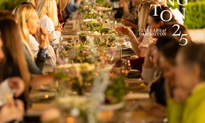 Guests seated at a long, outdoor, elegantly set table enjoy a meal amid lush greenery. Overlay text reads: "BABINGTON 25 YEARS of BABINGTON 25."
